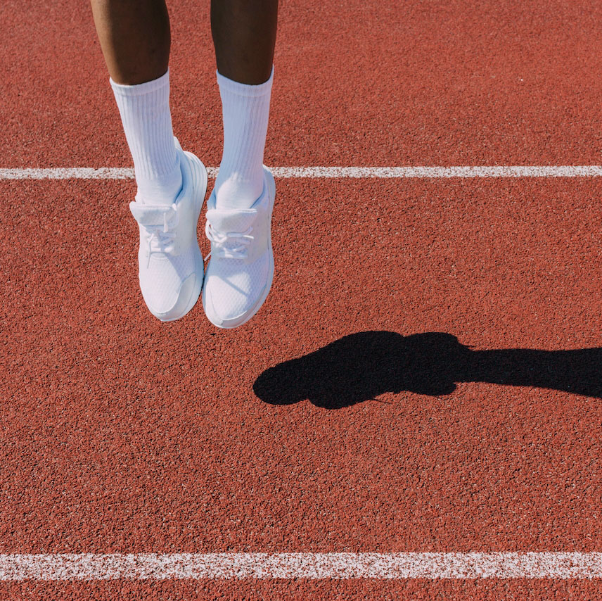 view of a person's feet, jumping up from a track