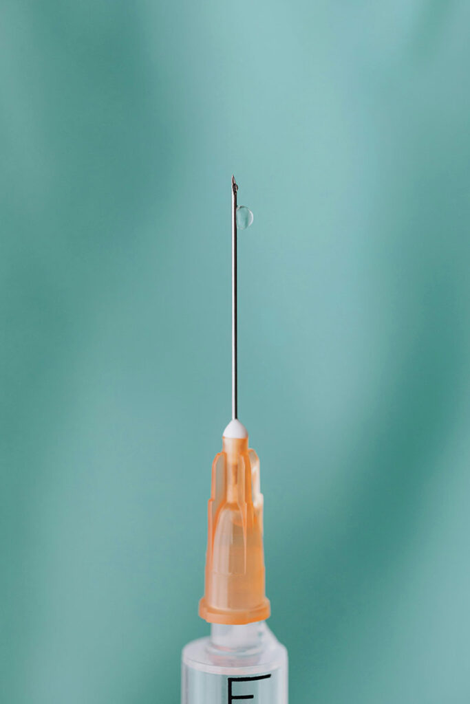 Syringe on green background